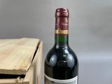 a bottle of wine sitting next to a wooden box