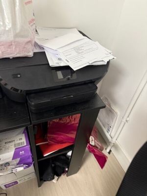 a printer sitting on top of a desk next to a chair