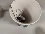 a white cup with ear buds in it sitting on a table