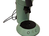 a green coffee maker sitting on top of a table