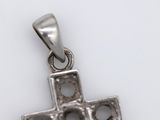 an image of a silver cross pendant on a white surface