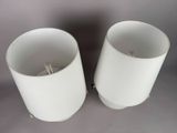 pair of white lamps on a gray surface with a gray background