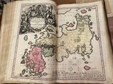 an old book with a map on it sitting on a table