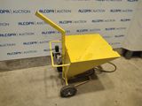 a yellow cart sitting in front of a wall with a sign behind it