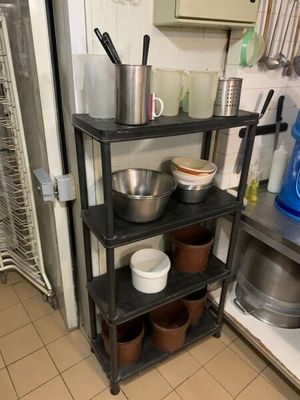 une étagère avec des casseroles et des poêles dans une cuisine