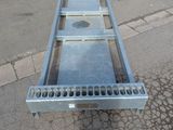 a metal bench that is sitting on the side of the road