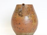 a brown vase that is sitting on a white surface