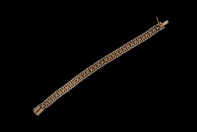 gros plan d'un bracelet en or sur fond noir