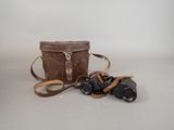 a brown bag with a pair of binoculars next to it
