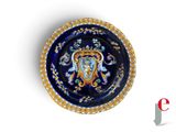 une assiette bleue et dorée sur laquelle est représenté un lion