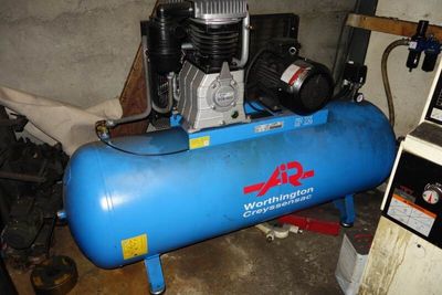 un compresseur d'air bleu posé sur un réservoir bleu