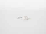 a close up of a diamond ring on a white surface
