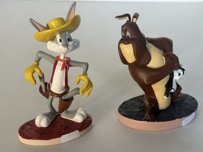 deux figurines représentant des insectes et un chat posées sur une table