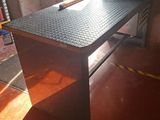 a metal work table with a black top in a garage