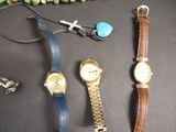 trois montres et un bracelet sont posés sur une table