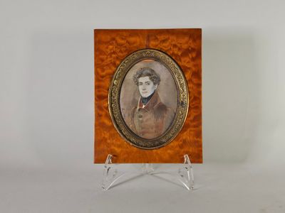 Une vieille photo représentant une femme en robe marron est posée sur un socle