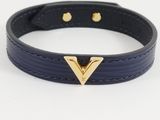 a close up of a black leather bracelet with a gold v on it