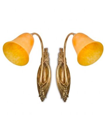 pair of brass wall lamps with orange shades on each side