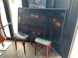 deux tabourets devant un grand écran de télévision