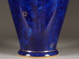 a blue vase with a gold decoration on it
