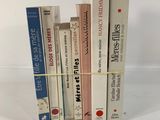 plusieurs livres sont empilés sur une surface blanche