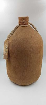 une cruche marron entourée d'une corde, posée sur une surface blanche