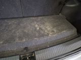 a dirty trunk of a car with the seat down