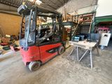 a red fork truck parked inside of a warehouse