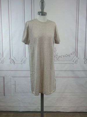 beige t - shirt on a mannequin stand in front of a white wall