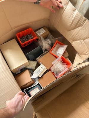 someone is holding a box full of assorted items in a room