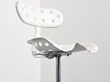 a white chair that is sitting on a metal stand