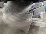 a pile of mattresses wrapped in plastic on the floor