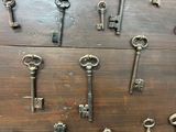 many old keys that are on a wooden table