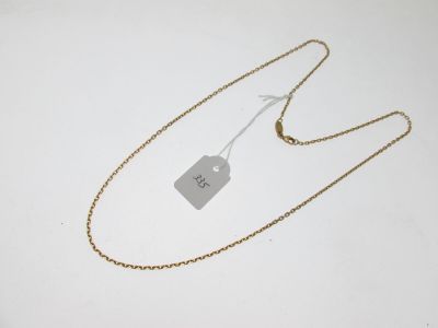 une chaîne en or à laquelle est accrochée une médaille, posée sur une surface blanche