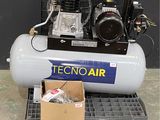 un petit compresseur d'air posé sur une palette, à côté d'une boîte de vis