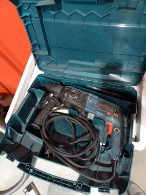 une boîte à outils bleue contenant une perceuse et un cordon d'alimentation