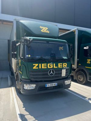 two trucks that are parked next to each other in front of a building