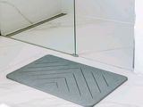 un tapis de bain posé sur le sol de la salle de bains