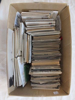 une boîte en carton remplie de journaux posée sur un lit