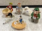 five figurines of people sitting on a table