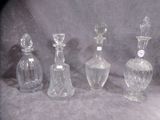 four clear glass bottles sitting next to each other on a gray surface