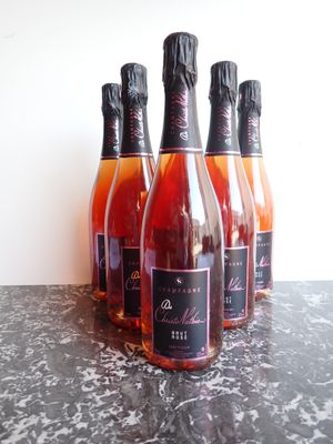 six bouteilles de vin sont alignées sur une table