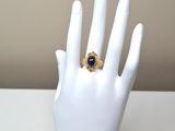 a ring on a mannequin hand with a blue stone