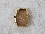 a close up of a gold ring on a white surface