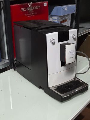 une machine à café en noir et blanc posée sur une table blanche