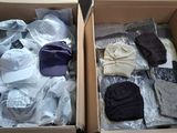 two boxes of clothing are packed in plastic wrap on the floor