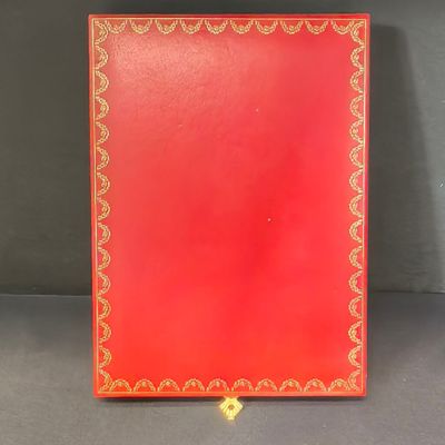 un livre rouge avec des bordures dorées et un liseré doré