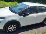 a small white car parked on the side of the road