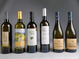 several bottles of wine are lined up in a row on a table