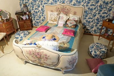 une chambre avec un lit, des commodes et une chaise